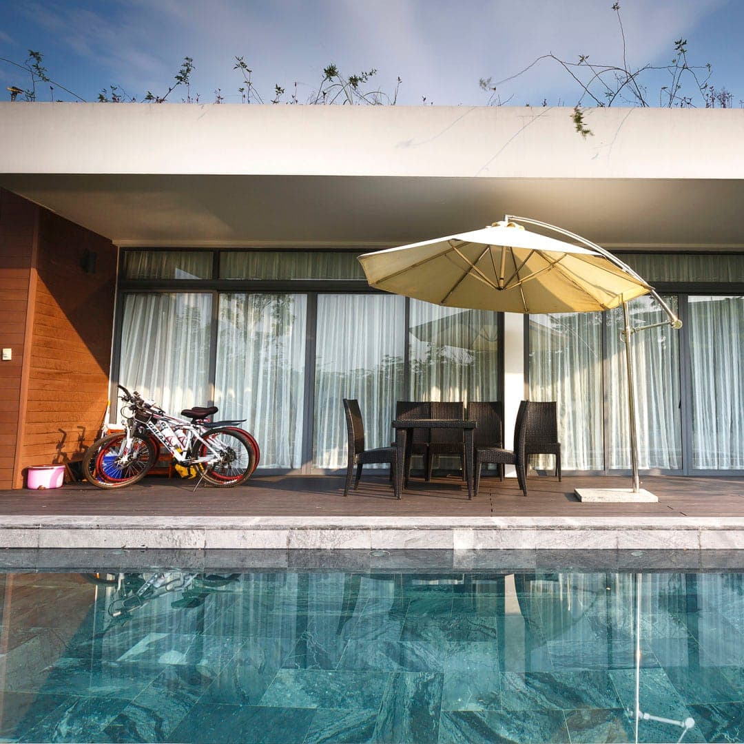 Piscina com mesa e bicicletas ao fundo