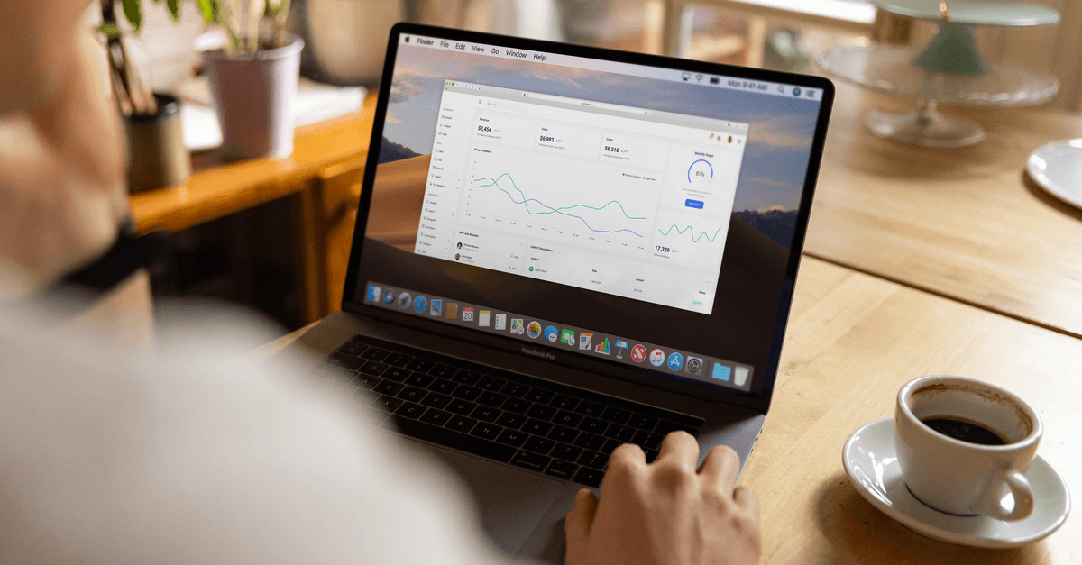 airbnb host calculating rental property fees on laptop with coffee — Foto: Firmbee.com (Pexels)