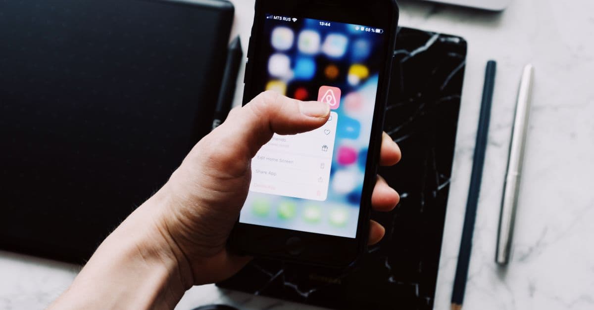 person using smartphone looking at vacation rental home booking app travel — Foto: ready made (Pexels)